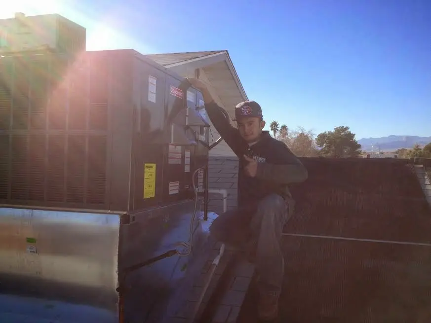 HVAC technician performing AC Tune-Up on a rooftop unit in Strawberry